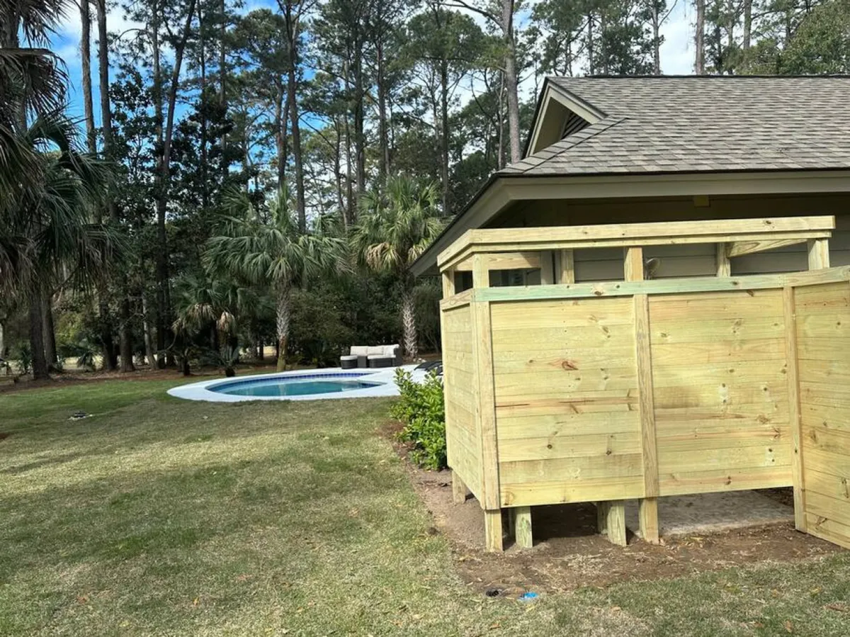 A view of the pool area framed by a wooden enclosure and enhanced landscaping, set under open skies. The space is designed for sunbathing, swimming, and stargazing—showcasing the versatility of the outdoor amenities through all seasons.