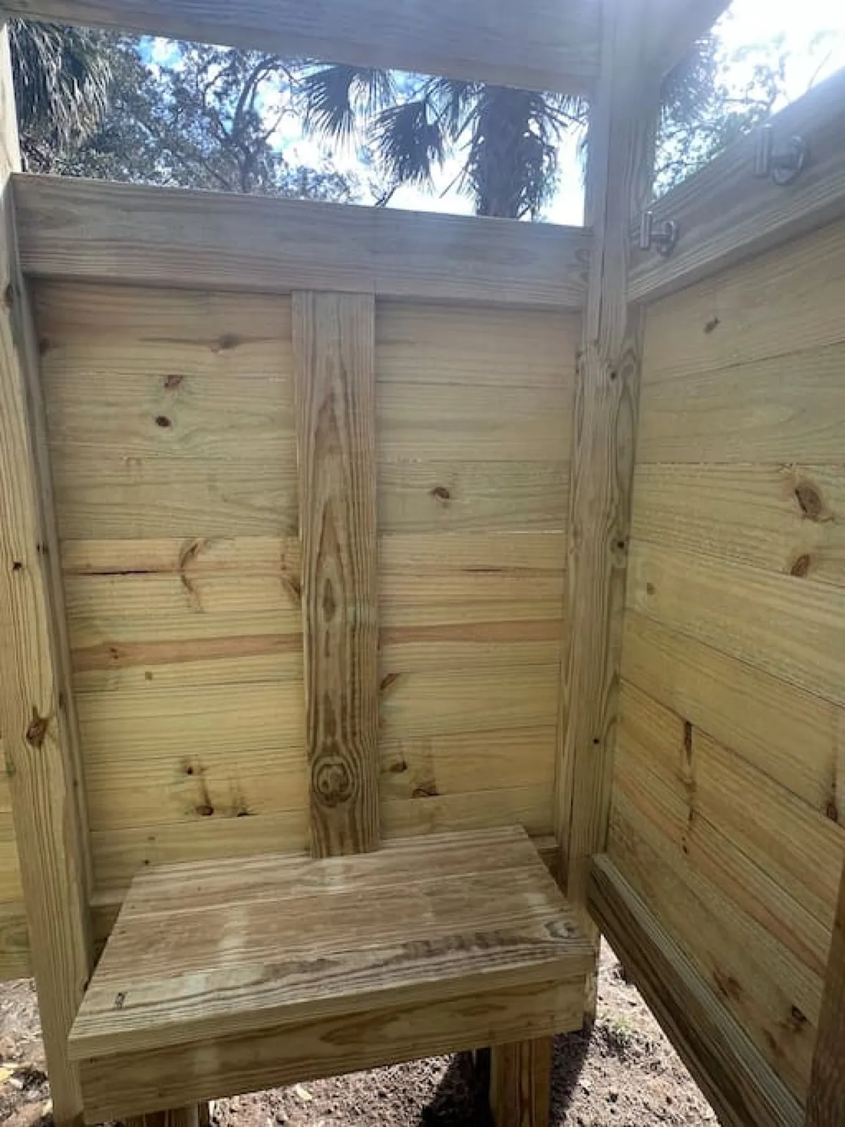 A wooden structure with a bench and open space, suggesting a practical area that connects with the outdoors. The natural materials and simple design evoke a sense of being at the threshold between indoor comfort and outdoor adventure.