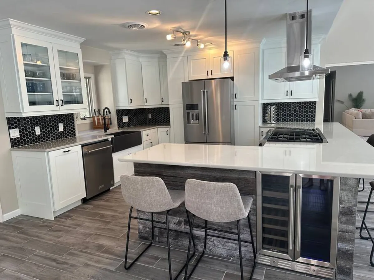 A welcoming and stylish kitchen centered around a spacious island, with stainless steel appliances, a striking honeycomb backsplash, and modern bar stools. The open layout is perfect for prepping meals while engaging guests or family.